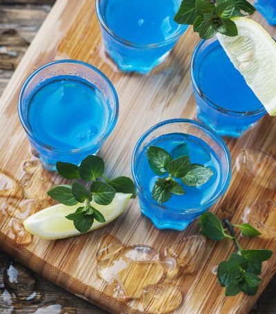Blue curacao liqueur with lemon on the wooden table